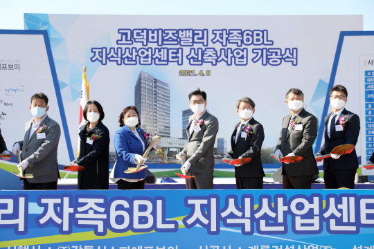 서울 강동구 이정훈 구청장(가운데)이 8일 고덕비즈밸리 지식산업센터 신축 사업 부지에서 열린 기공식에 참석해 첫 삽을 뜨는 퍼포먼스를 하고 있다.[사진=서울 강동구 제공]